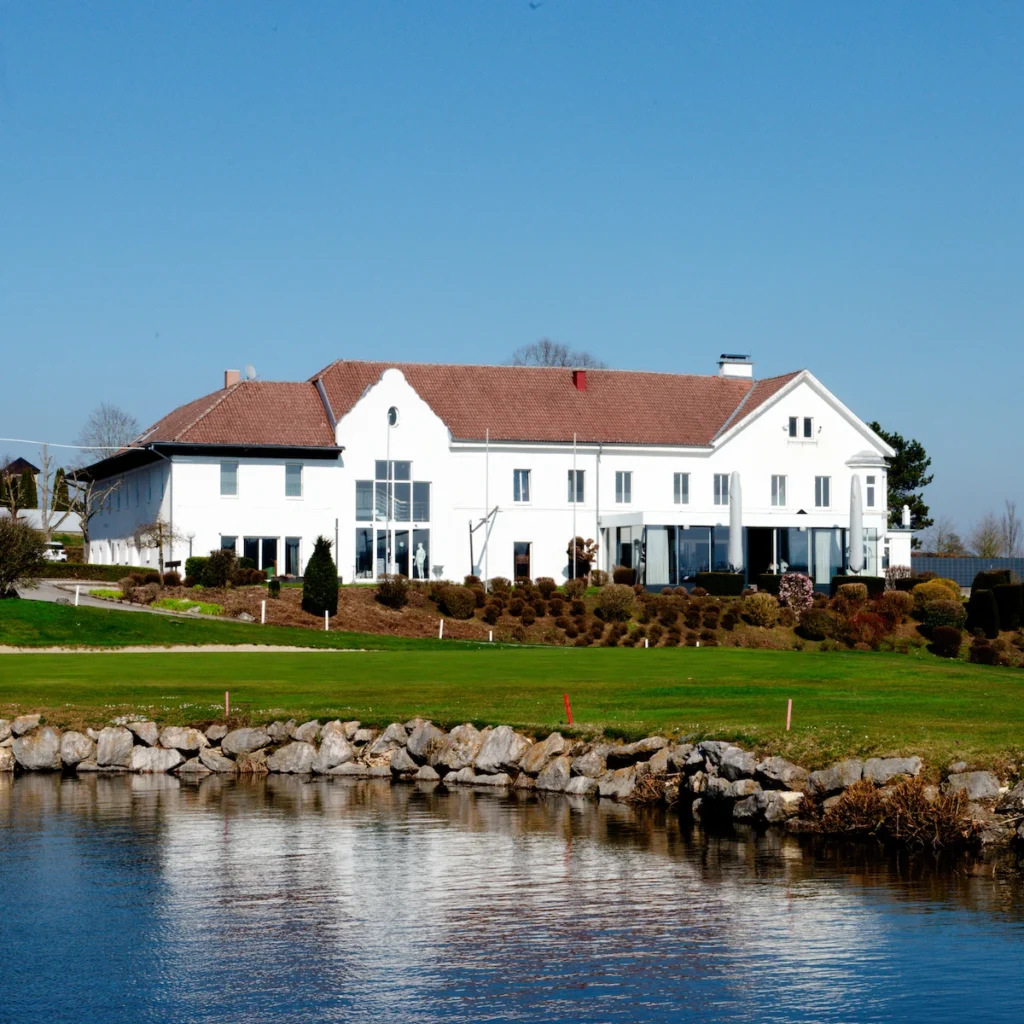 Außenansicht des Restaurants Birdie im Golfclub Wels mit Teich und Golfplatz