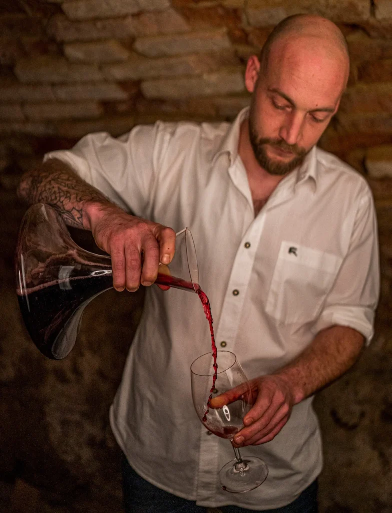 Jürgen Schliessleder schenkt Rotwein in ein Glas im Gewölbekeller des Restaurants Birdie in Wels