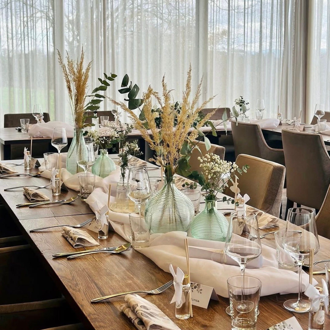Festlich gedeckter Tisch mit Glasvasen, Trockenblumen und eleganter Tischdekoration im Restaurant Birdie in Wels